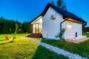 Nowoczesny domek spa oświetlony nocą, na tle zieleni