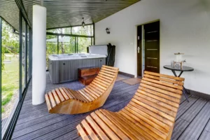 Zabudowany taras ze spa – leżaki i jacuzzi z widokiem na ogród