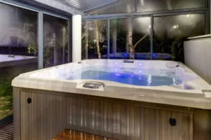 Jacuzzi w przeszklonym mini spa nocą z podświetleniem LED