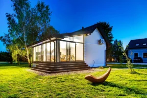 Strefa relaksu z drewnianymi leżakami i jacuzzi w oszklonym domku spa