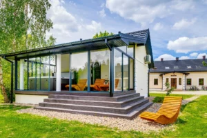 Widok z boku na domek spa i drewniany leżak w otoczeniu zieleni