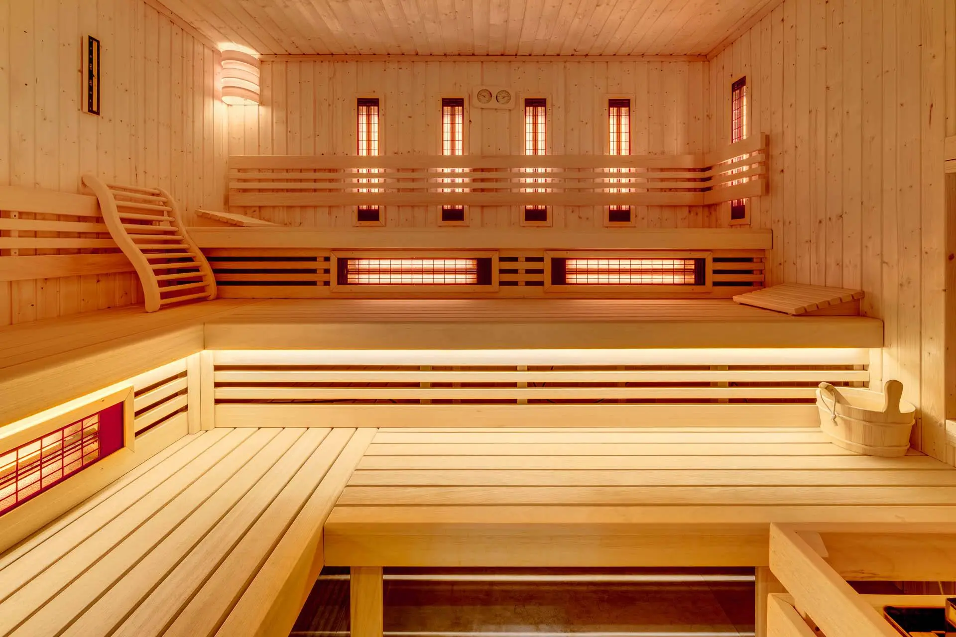 Panoramiczny widok na przestronną saunę infrared z trzema poziomami siedzisk